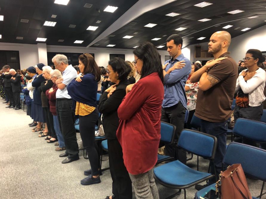 Imagem do público em oração proposta por Anselm Grün no final da palestra